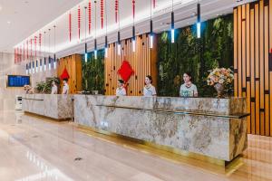 a group of people standing at a counter in a building at Wenzhou Hangbin International Hotel in Wenzhou