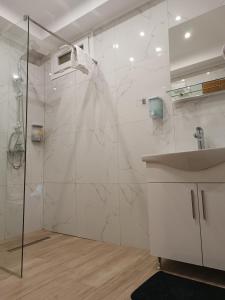 a white bathroom with a shower and a sink at Pablo Boutique Rooms in Vétrina
