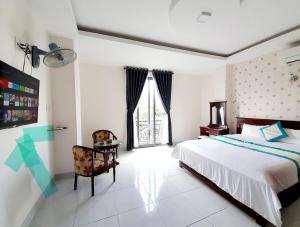 a bedroom with a bed and a chair and a window at HOTEL VIỆT ÚC, H17 Phan Huy Chú, phường Vũng Tàu in Vung Tau