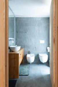 a bathroom with two sinks and two toilets in it at Wome house con idromassaggio in Campo