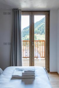 a bedroom with a bed and a large window at Wome house con idromassaggio in Campo