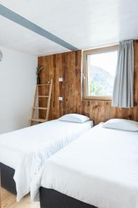 two beds in a room with a window at Wome house con idromassaggio in Campo