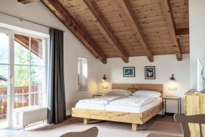 ein Schlafzimmer mit einem Bett und einem großen Fenster in der Unterkunft Gästehaus Quirin in Garmisch-Partenkirchen