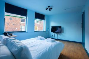 a blue room with a bed and a tv at The Crown & Anchor in Manchester