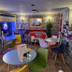 a room with tables and chairs and a couch at Ebenezer's Place in Broadstairs