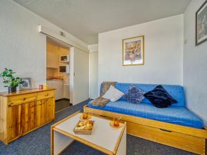 - un salon avec un canapé bleu et une table dans l'établissement Apartment Lunik Orion-41 by Interhome, au Corbier