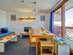 een woonkamer met een tafel en stoelen en een bank bij Apartment Lunik Orion-41 by Interhome in Le Corbier