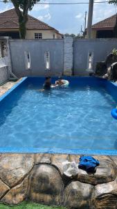 due persone in una piscina in un cortile di Homestay D'Putra Bertam a Kepala Batas