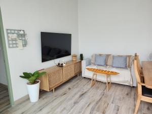 salon z kanapą i telewizorem w obiekcie Self house (Cozy private house) w mieście Hat Yai