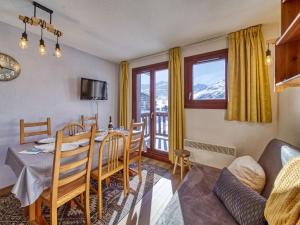 a dining room with a table and chairs and a balcony at Apartment Balcons D'Olympie-3 by Interhome in Les Menuires