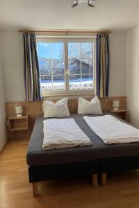 a bed in a room with a large window at Apartment Top 4 by Interhome in Sankt Margarethen im Lungau