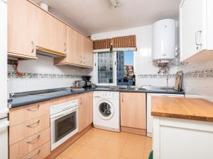 eine Küche mit Holzschränken, einer Waschmaschine und einem Trockner in der Unterkunft Apartment Bellavista del Puerto by Interhome in Estepona