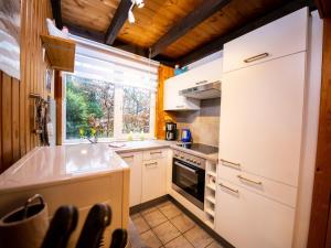 cocina con nevera blanca y ventana en Holiday Home Ferienpark Extertal-1 by Interhome, en Rott