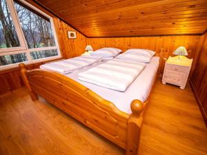 RottにあるHoliday Home Ferienpark Extertal-1 by Interhomeの木製の部屋に大型ベッドが備わるベッドルーム1室が備わります。