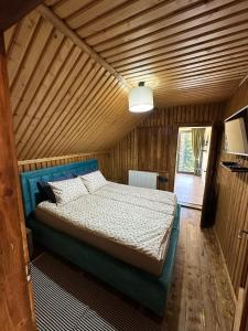 a bedroom with a bed in a wooden room at Black Wolf PĂLTINIȘ in Păltiniş +46 photos