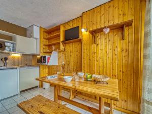 里蒙紐耶的住宿－Studio Les Asters-35 by Interhome，厨房设有木墙和木桌