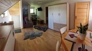 a kitchen and living room with a table and chairs at Apartament Grel in Nowy Targ