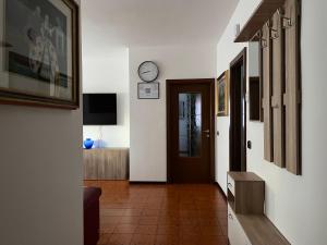 a hallway with a door and a clock on the wall at Appartamento spazioso con 3 camere da letto in Riva del Garda