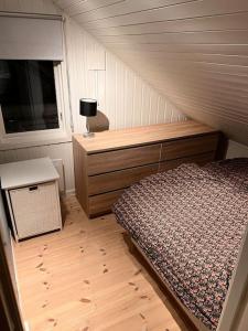 een slaapkamer met een bed, een dressoir en een raam bij Tromsø’s best location? City & Nature 5 mins away. in Tromsø