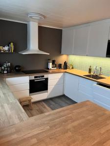 a kitchen with white cabinets and a stove top oven at Tromsø’s best location? City & Nature 5 mins away. in Tromsø