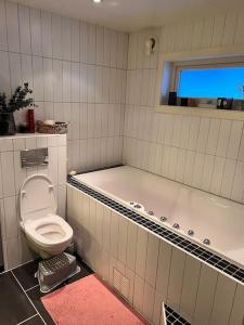 Tromsø’s best location? City & Nature 5 mins away. في ترومسو: حمام مع مرحاض وحوض استحمام