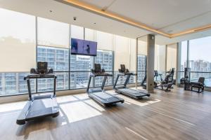 - une salle de sport avec plusieurs tapis de course et une télévision à écran plat dans l'établissement STAY BY LATINEM Luxury 2BR Holiday Home W1504 near Burj Khalifa, à Dubaï