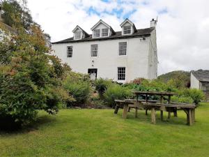 a picnic table in front of a white building at 1 Bed in Keswick 86395 in Rosthwaite