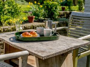 a tray of croissants and coffee cups on a table at 1 bed property in Tetbury 87442 
