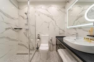 a bathroom with a white toilet and a sink at Ozero Vita in Nizhniy Studenyy