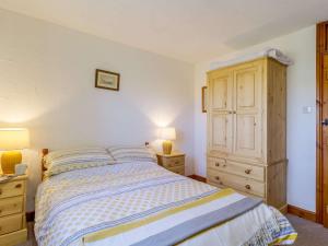 a bedroom with a bed and a wooden cabinet at 1 bed in Wroxham 87415 in Hainford