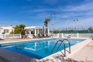 a swimming pool with blue water and a white fence at rentafive - Nuevo - A/A - Barbacoa - Tenis in Santa Pola
