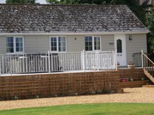 a house with a brick retaining wall and a white fence at 1 bed in Cinderford 88272 in Cinderford