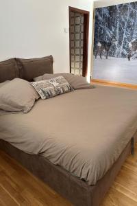 a large bed in a bedroom with a picture of a dog at Studio Frassan Apartments-3 by Interhome in Madonna di Campiglio