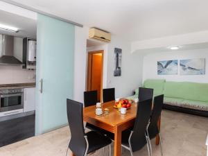 eine Küche und ein Esszimmer mit einem Holztisch und Stühlen in der Unterkunft Holiday Home Mirador de las Islas 5 by Interhome in Peñíscola