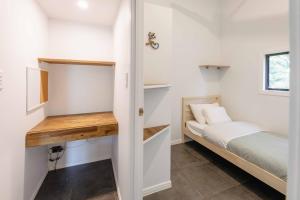 a small bedroom with a bed and a desk at kin kin cottage, Noosa hinterland, walk to town. in Kin Kin