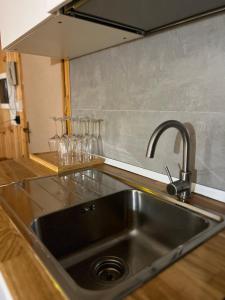 a kitchen sink with a faucet and wine glasses at Cataleya Laceno in Villaggio Laceno +40 photos