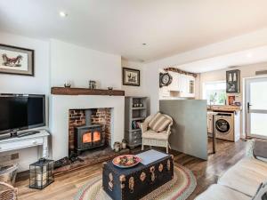 a living room with a fireplace and a tv at 2 Bed in Holt 87768 in Baconsthorpe