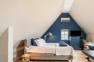 een slaapkamer met een blauwe muur en een bed bij B&B Studio/Appartement Bij Zee in Stellendam