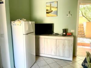 cocina con nevera blanca y TV en CasaTobia25, en Costa Paradiso