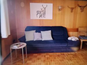 ein blaues Sofa im Wohnzimmer mit einem Tisch in der Unterkunft Holiday Home Landhaus Klara by Interhome in Eisenbach