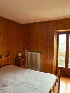 een slaapkamer met een groot bed en een raam bij Maison Marcel Sarre in Aosta