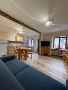 een woonkamer met een blauwe bank en een tafel bij Maison Marcel Sarre in Aosta
