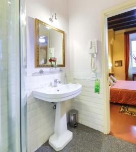 a bathroom with a sink and a mirror and a bed at Casa De' Fiori in Rome +68 photos