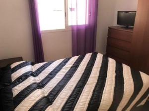 a bedroom with a bed and a dresser and a window at Apartamento Miami Playa, 2 dormitorios, 4 personas - ES-9-152 in Hospitalet de l'Infant