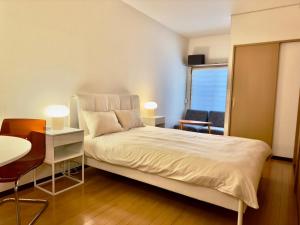 1 dormitorio con 1 cama, 1 mesa y 1 silla en Cube Stay 北東京, en Tokio