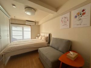 1 dormitorio pequeño con 1 cama y 1 sofá en Cube Stay 北東京, en Tokio
