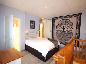 ein Schlafzimmer mit einem Bett mit einem Baumbild an der Wand in der Unterkunft Appartement Bagnères-de-Luchon, 2 pièces, 2 personnes - FR-1-313-229 in Luchon