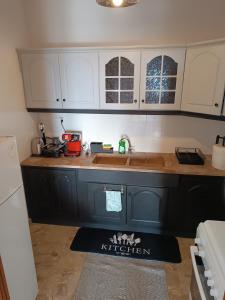 a kitchen with black and white cabinets and a sink at Pablo Boutique Rooms in Vétrina +15 photos