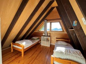 a attic room with two beds and a window at Chalet Villard-de-Lans, 3 pièces, 6 personnes - FR-1-761-33 in Villard-de-Lans