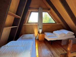 two beds in a small room with a window at Chalet atypique plein de charme avec garage et balcon, idéal pour familles - FR-1-761-33 in Villard-de-Lans +5 photos